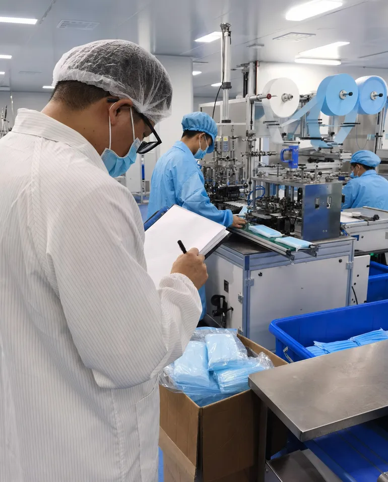 Third-party auditor conducting factory inspection of medical mask production facility