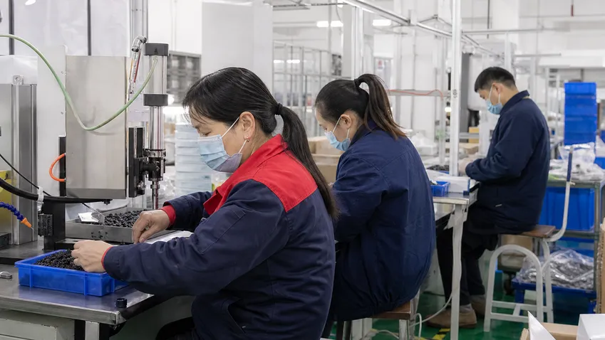 Workers in manufacturing facility wearing disposable medical masks