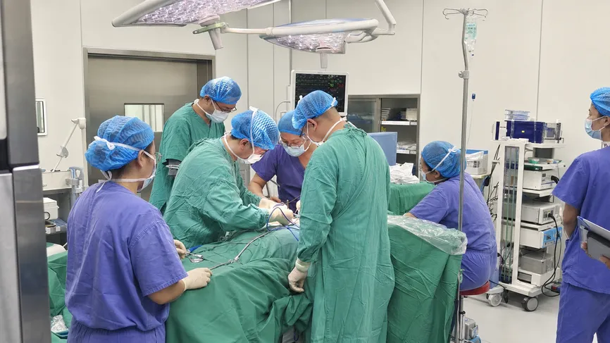 Hospital surgical suite with staff wearing disposable medical caps during procedure