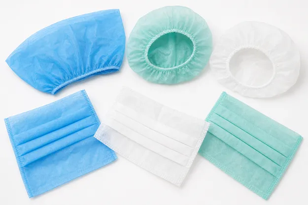 Disposable medical caps in flat-cut and pleated nonwoven construction with elastic band closure