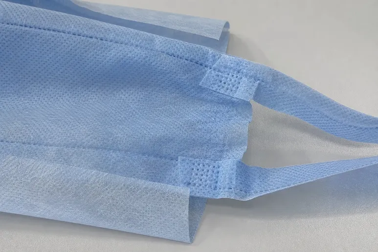 Close-up of reinforced tie-back closure on surgical medical cap showing ultrasonic weld points