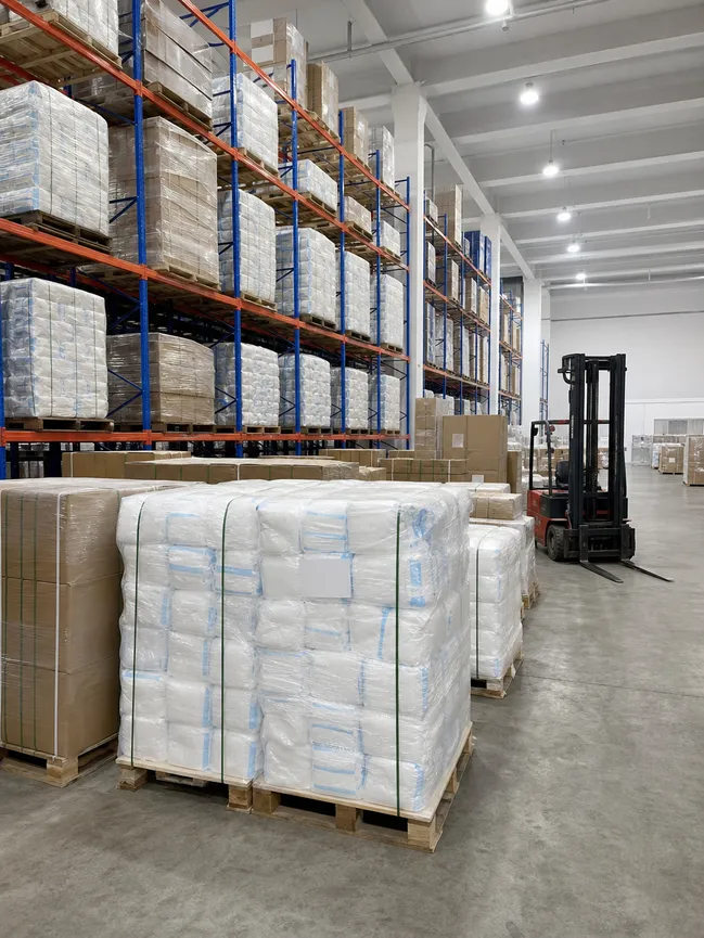 Strategic PPE reserve warehouse with palletized medical protective coverall inventory for government emergency stockpile