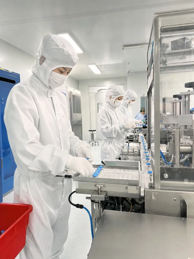Pharmaceutical cleanroom workers wearing medical-grade coveralls for contamination control