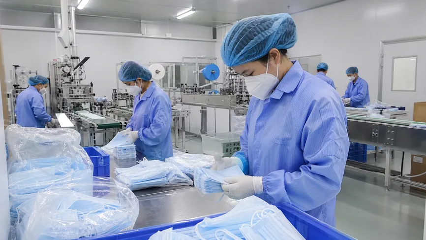 Workers in manufacturing facility wearing certified respiratory protection masks